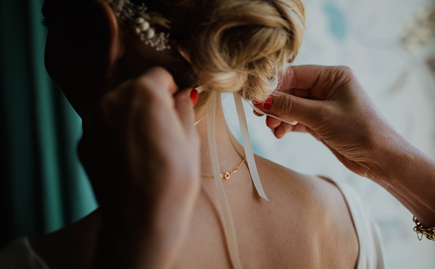 Detailarbeit an der Hochzeitsfrisur einer Braut